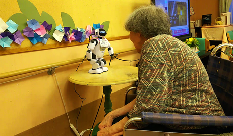 ロボットと会話するゲスト。西東京市の高齢者施設にて。2018年度研究助成プログラム特定課題先端技術と共創する社会「介護ロボットの社会実装モデルに関する国際共同研究～人・ロボット共創型医療・介護包括システムの構築に向けて～」（撮影：岡本佳美。提供：尾林和子）